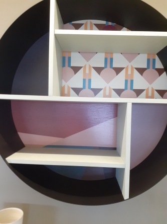 Libreria sospesa con schienale decorato e struttura in ferro