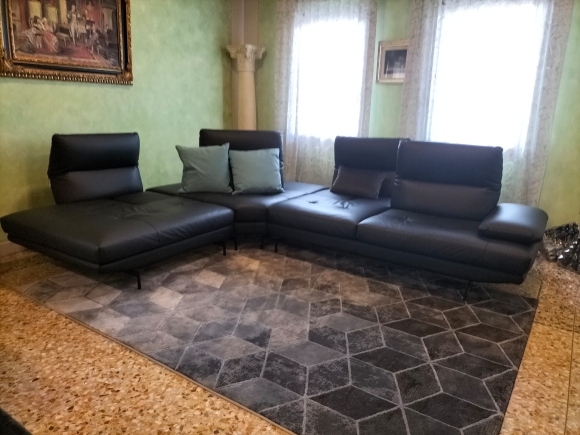 Divano in pelle con schienali traslanti, poggiatesta regolabili manualmente e bracciolo estensibile