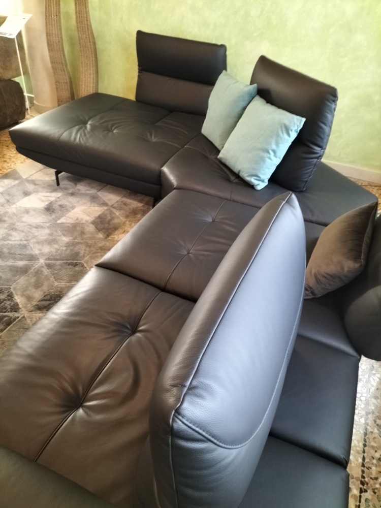 Divano in pelle con schienali traslanti, poggiatesta regolabili manualmente e bracciolo estensibile